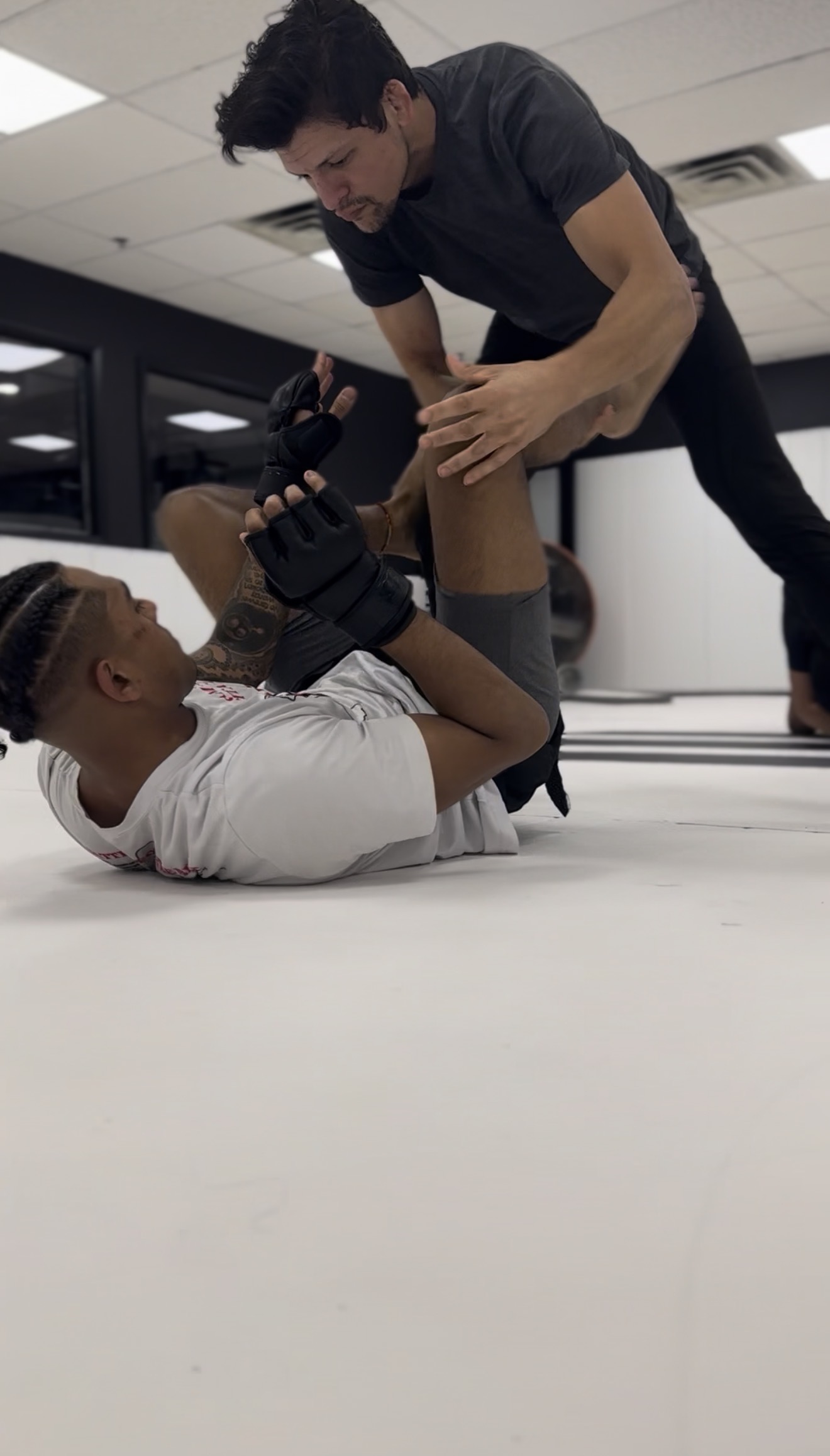 Coach Eric coaching a member through MMA ground technique